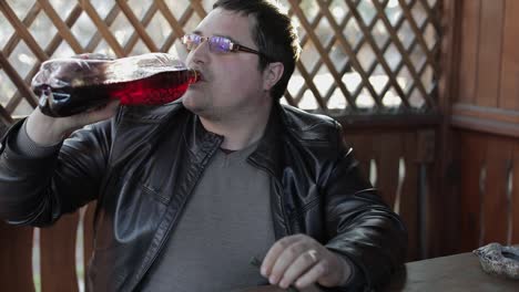 Two-men-sit-at-the-table-and-drink-beer-from-plastic-bottles.-Happy