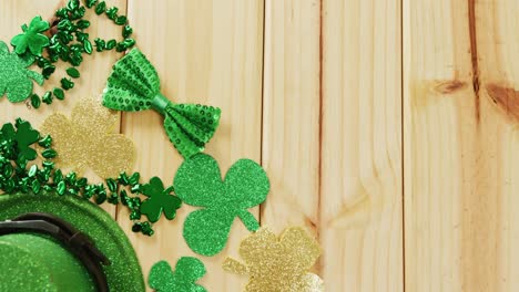 video of st patrick's green hat, shamrock and bow tie on wooden background