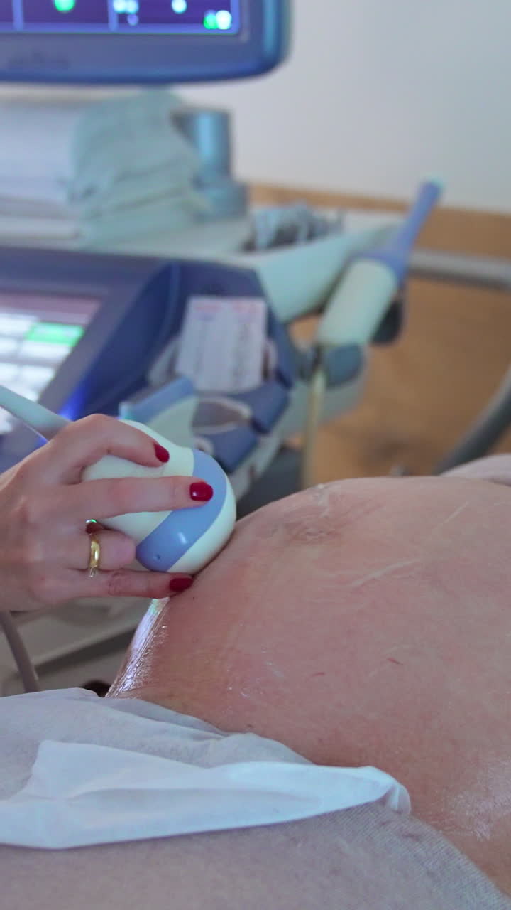 Future mother at doctor's examination. Ultrasonic diagnostics in the present-day maternity clinic. Vertical video