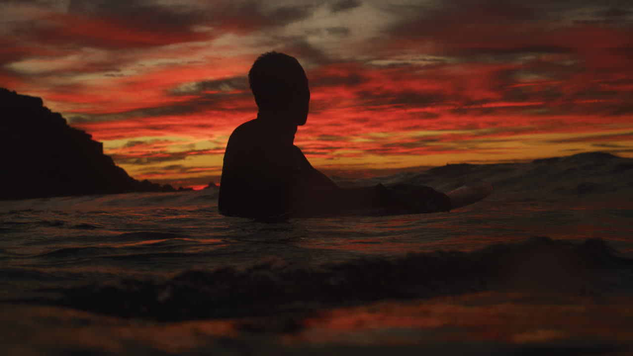 Surfero en puesta del sol