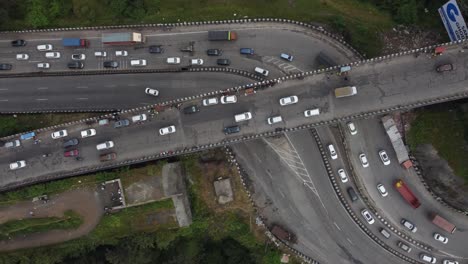 Schöne-Luftaufnahme-Von-Oben-Nach-Unten-Von-Der-Autobahnkreuzung-Mit-Autos-Und-Schweren-Transportfahrzeugen,-Die-Jeweils-Durch-Ein-Tiefes-Tal-Geschnitzt-Sind