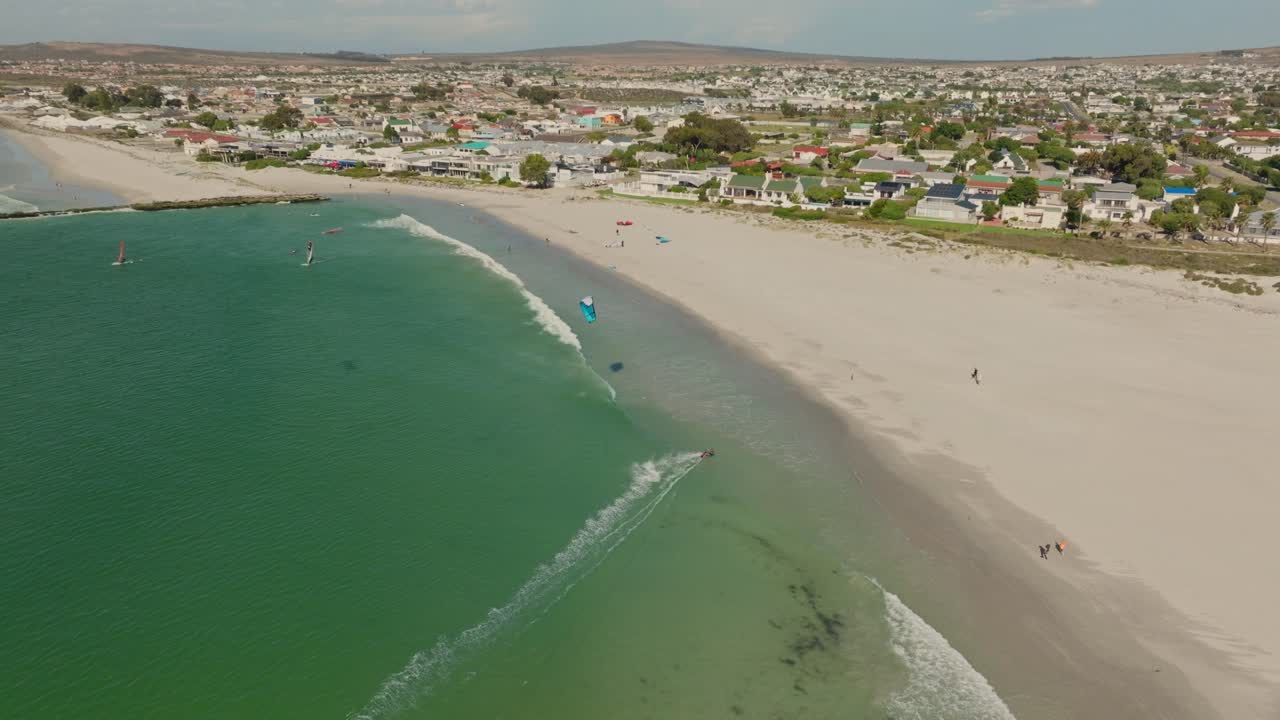 tomada de un drone de un kitesurfista durante el mediodía, en el fondo la ciudad de langebaan