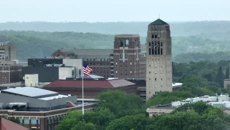 Amerikanische-Flagge-Weht-Neben-Dem-Uhrenturm-Der-University-Of-Michigan,-Dem-Burton-Memorial-Tower