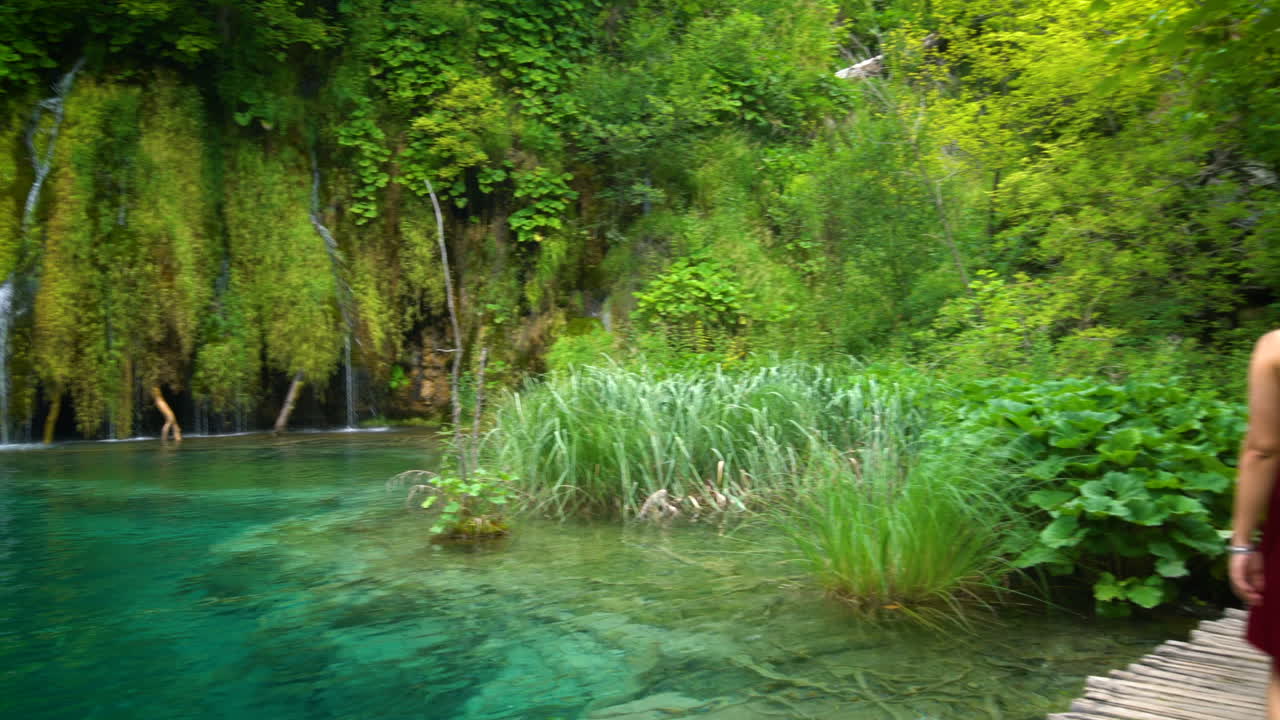 una mujer viajera disfruta de una cascada en los lagos de plitvice.
