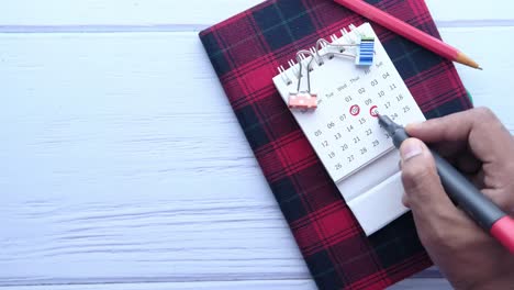 person writing on a calendar