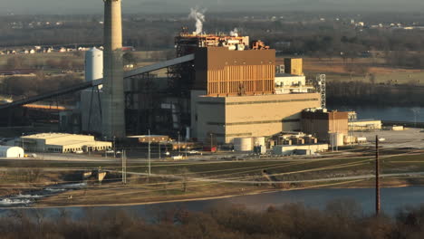 telephoto aerial shot reveal of flint creek power plant by lake swepco, tilt up