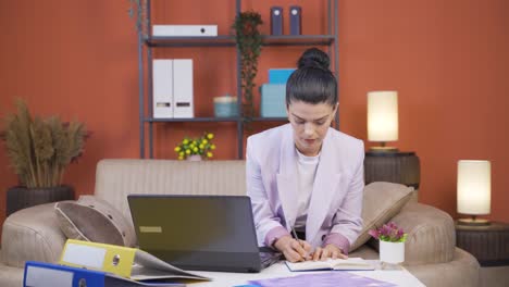 trabajadora de oficina en casa mujer joven trabajando en serio y concentrada.