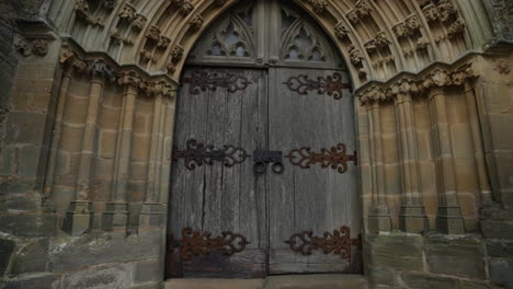 old wooden door with metal hinges in a stone archway