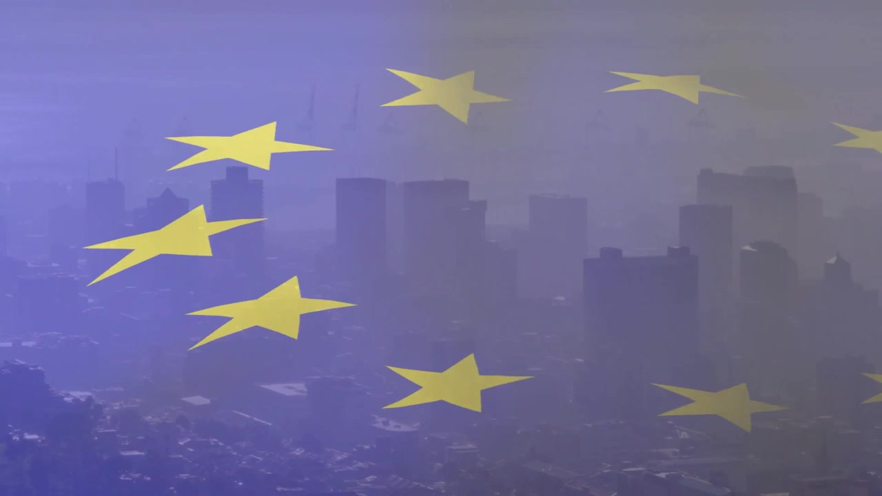 Vento leggero che fa sventolare la bandiera dell'UE sullo skyline, con le stelle gialle che si spostano e si disperdono.