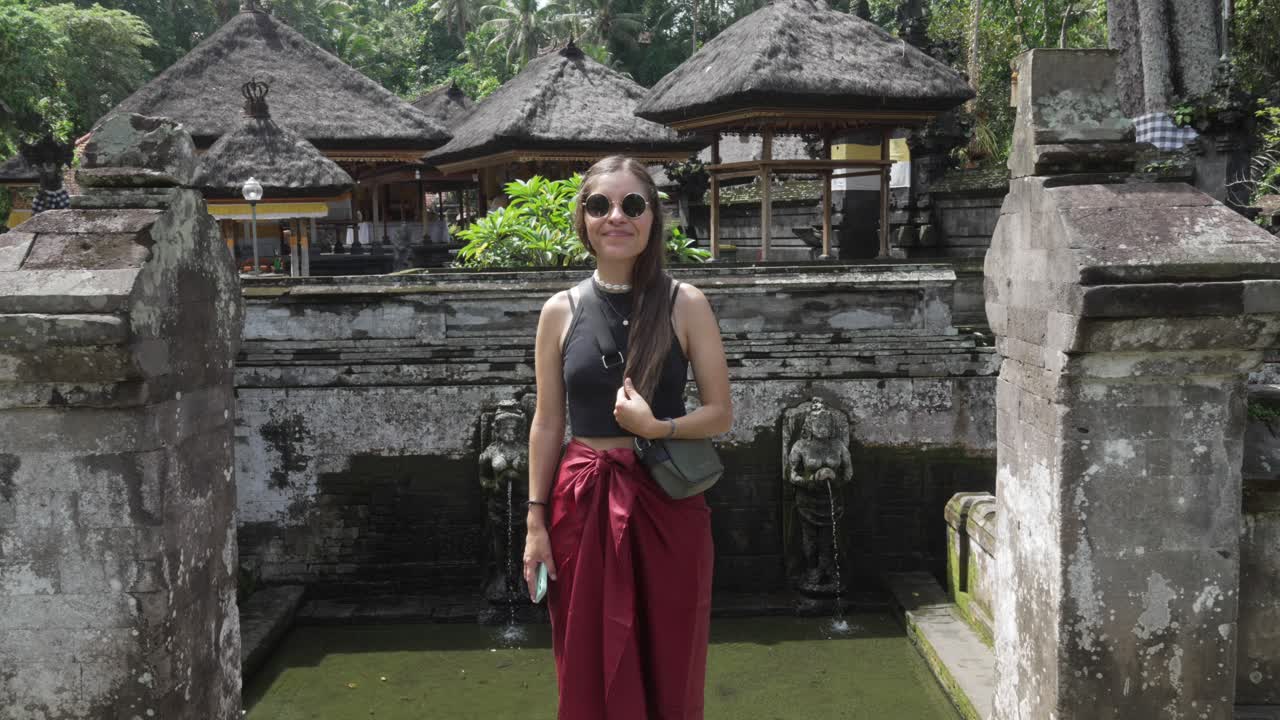 Western tourist Balinese temple Ubud Bali Indonesia Goa Gajah posing in holiday