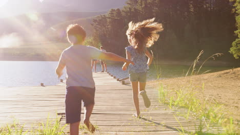 Kids-run-to-join-parents-admiring-view-on-jetty,-slow-motion