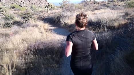 Woman-running-through-desert-landscape