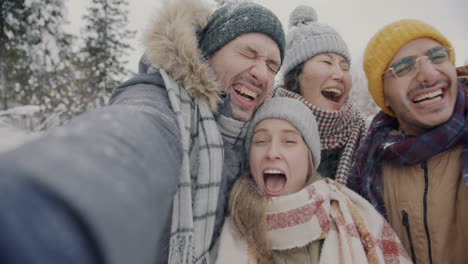 happy friends taking a selfie in the snow