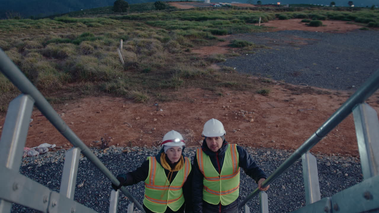 Engineers Going Upstairs and Having Conversation at Wind Farm