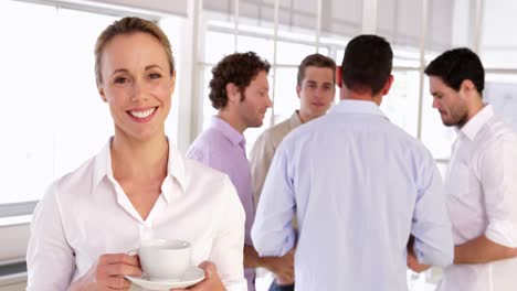 Cheerful-businesswoman-holding-a-cup-