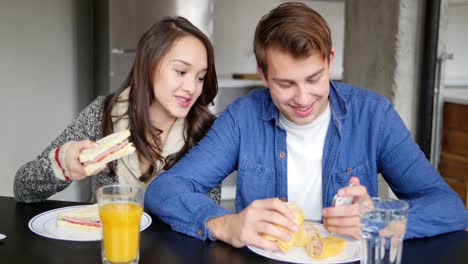 couple using mobile phone while having breakfast