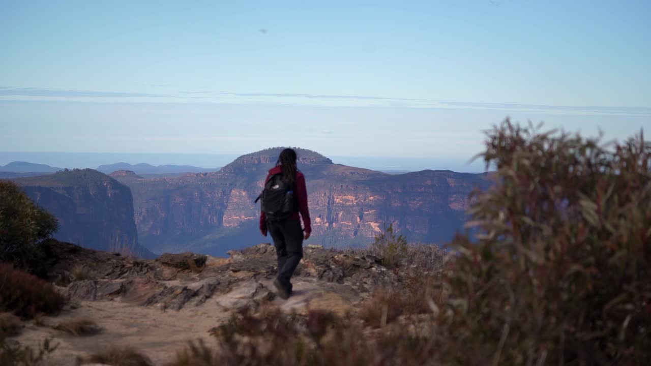 chica aborigen australiana mirando hacia las montañas azules, australia
