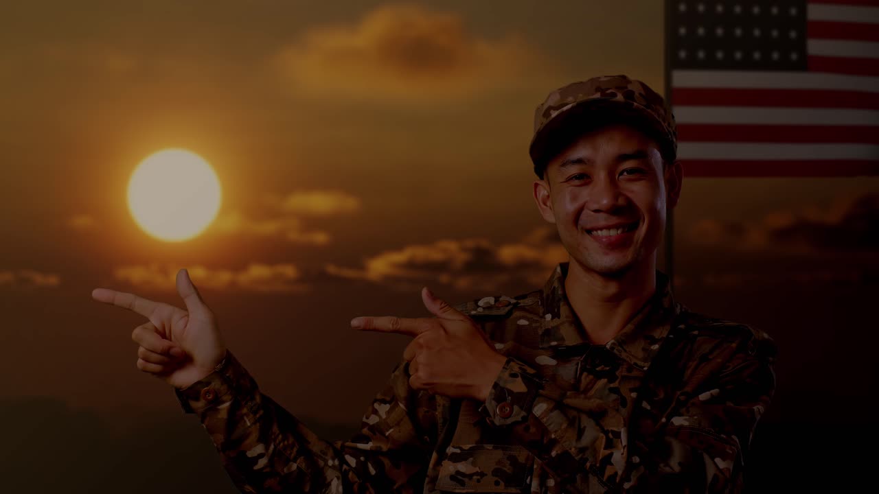 primer plano de un soldado asiático sonriendo y señalando hacia un lado mientras está de pie con la bandera de los estados unidos, hora de la puesta del sol