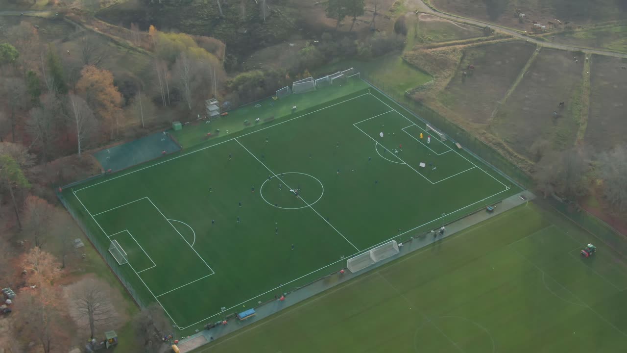 воздушный снимок футболистов с беспилотником, вращающимся вокруг, солнечные лучи проникают сквозь