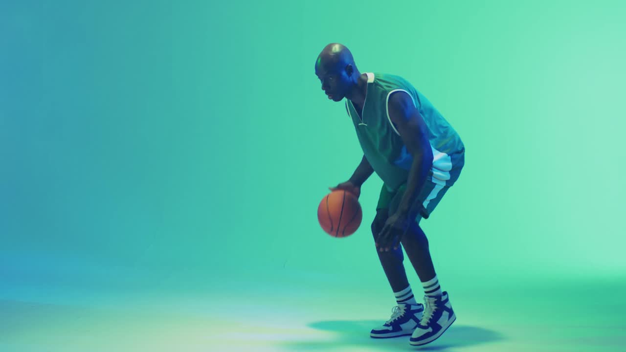 Video pemain basket pria Afrika-Amerika memantulkan bola di latar belakang biru