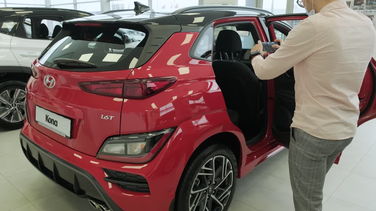 concesionario de automóviles hyundai. el gerente de concesionarios toma fotos de un automóvil nuevo para la venta. una visión general de los nuevos automóviles de prestigio en la sala de exhibición. sars para la venta en concesionista oficial de hyundai