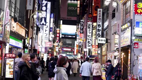 calle urbana abarrotada con letreros de neón por la noche