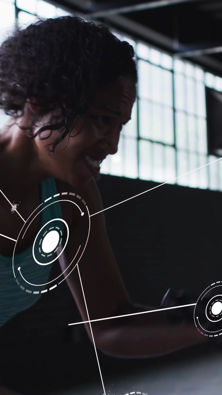 Kvinde griber håndvægt, aktiverer HUD-overlejringer, mens hun udfører curls og roning til styrketræning