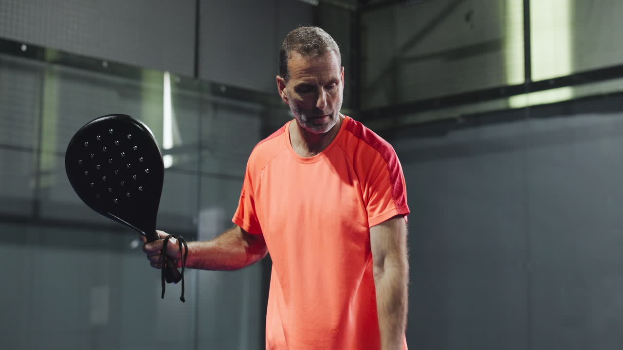 Man playing paddle tennis indoors