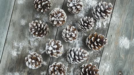 pine cones decorated with snow on wooden background