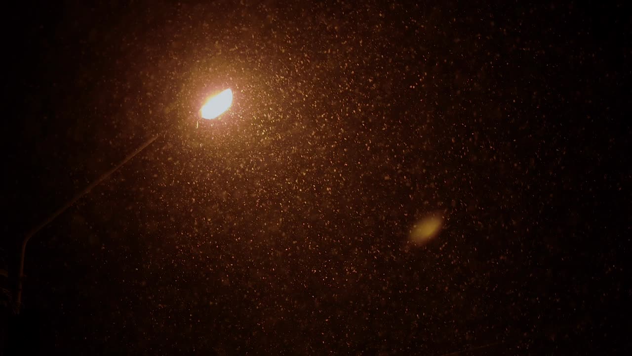 luces de la ciudad en una helada noche de invierno, tormenta de nieve, luz cálida