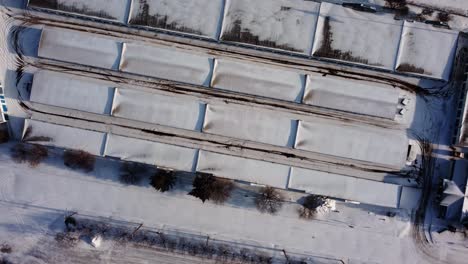 a view from above of storage warehouse roofs covered with snow
