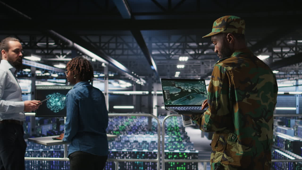 Military server hub technician reviewing tactical dashboard on laptop