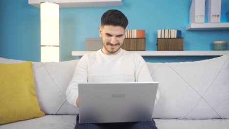 un joven que usa una computadora portátil en secreto.
