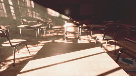 view to classroom with tables and small blackboard and grungy walls