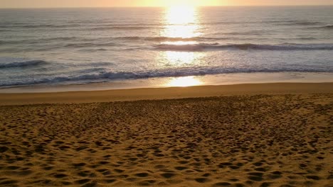 sunset beach and ocean shot, flying slowly towards the sun setting over the ocean
