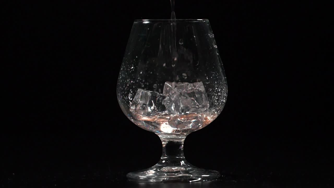 Filling Glass with Drink on the Rocks Slow Motion 4K