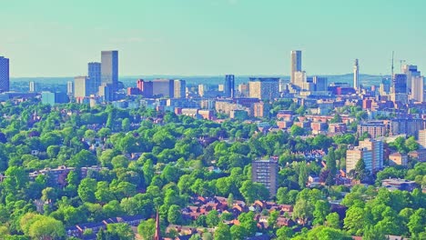 birmingham city skyline and iconic landmarks towering over the vibrant greenery of cannon hill park in summer, providing a sweeping vista of the city and its natural surroundings
