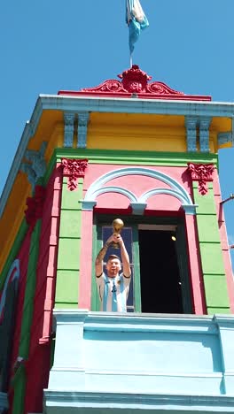 vertical of lionel messi holding soccer world cup in caminito, la boca, buenos aires argentina travel destination