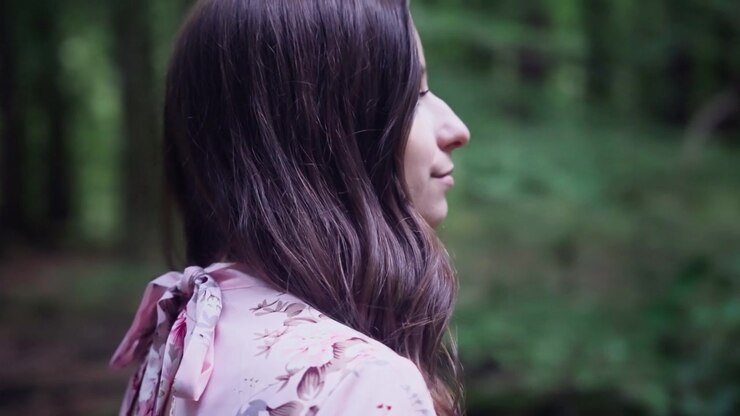 Ritratto di profilo di una bella donna europea che cammina nella foresta. Primo piano, slow motion