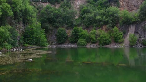 Vista-Estática-Del-Hermoso-Lago-Verde-Con-Agua-Clara-Y-Formación-De-Rocas-Erosionadas-En-El-Fondo,-Día-De-Verano