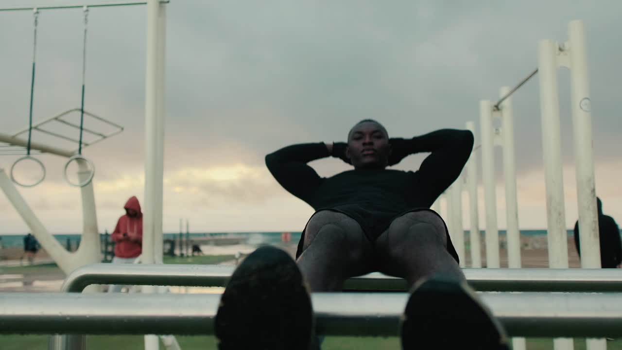 Young Man Doing Sit-Ups at an Outdoor Calisthenics Gym