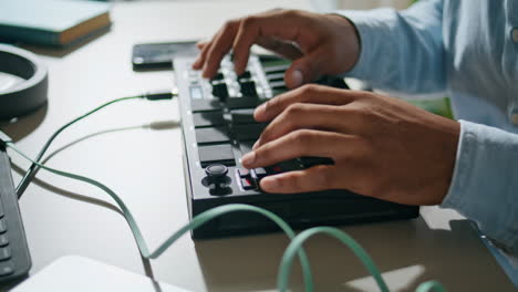 man hands using console keyboard closeup. unknown dj pushing buttons mixing song