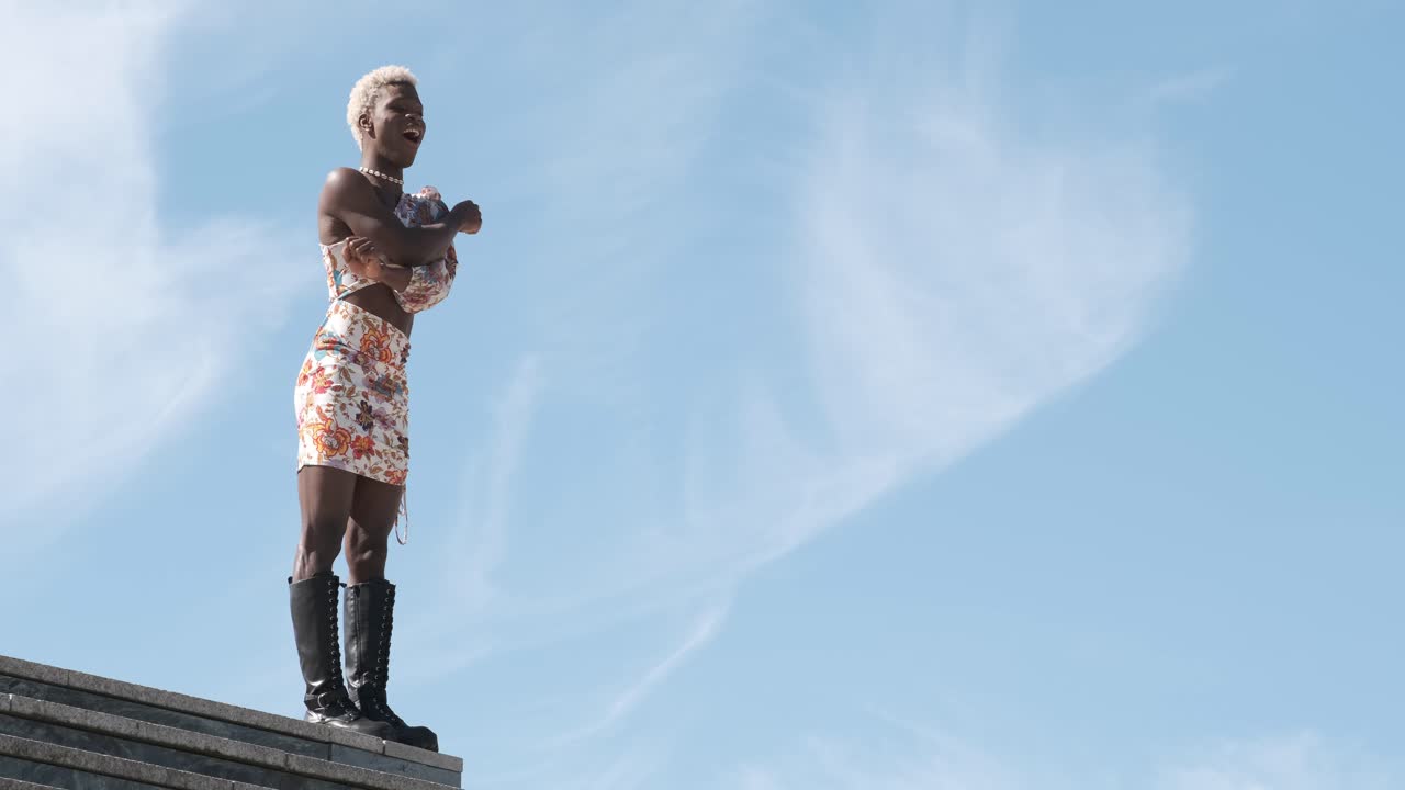 Happy transgender person enjoying dancing outdoors.
