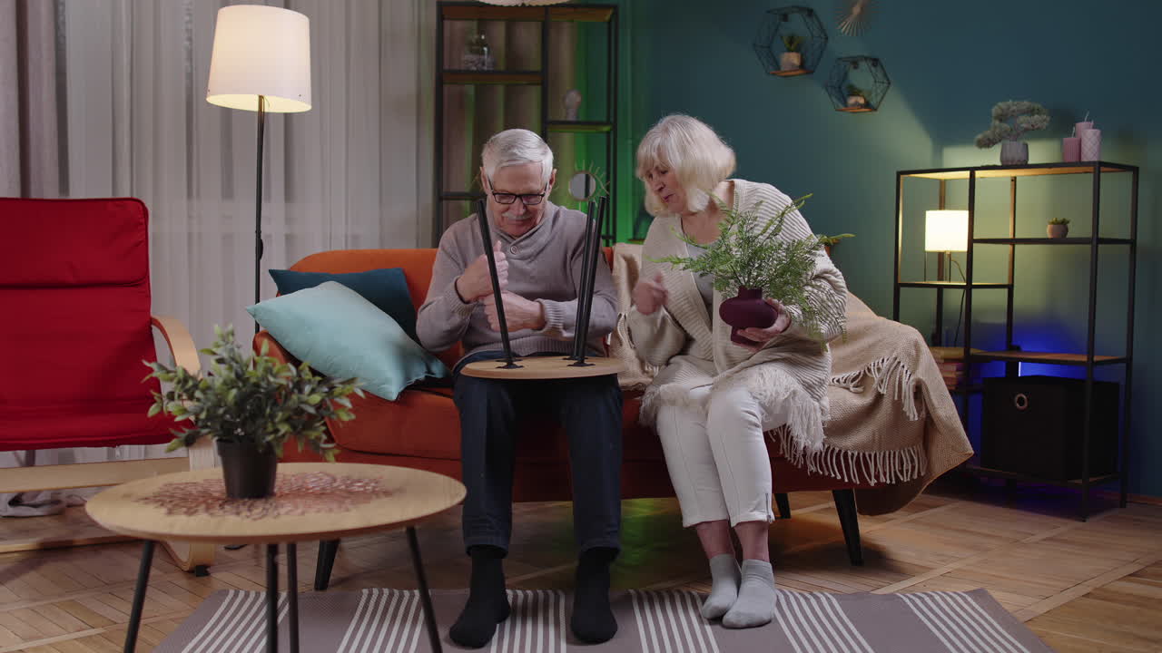 Senior mature old man woman family assembling furniture at home, collect, repair, fixing, teamwork