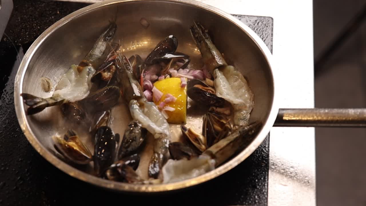 Chef Adding Ingredients to Seafood in a Pan