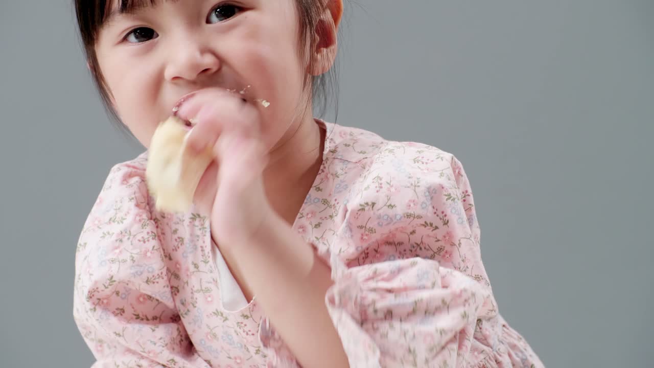 Bambino/a che mangia un dolce e si sporca tutta la faccia.