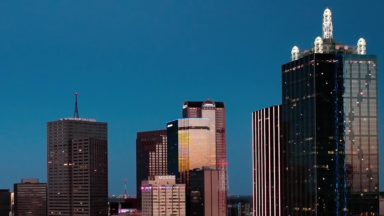 El centro de Dallas por la noche muestra edificios altos y luces de la ciudad