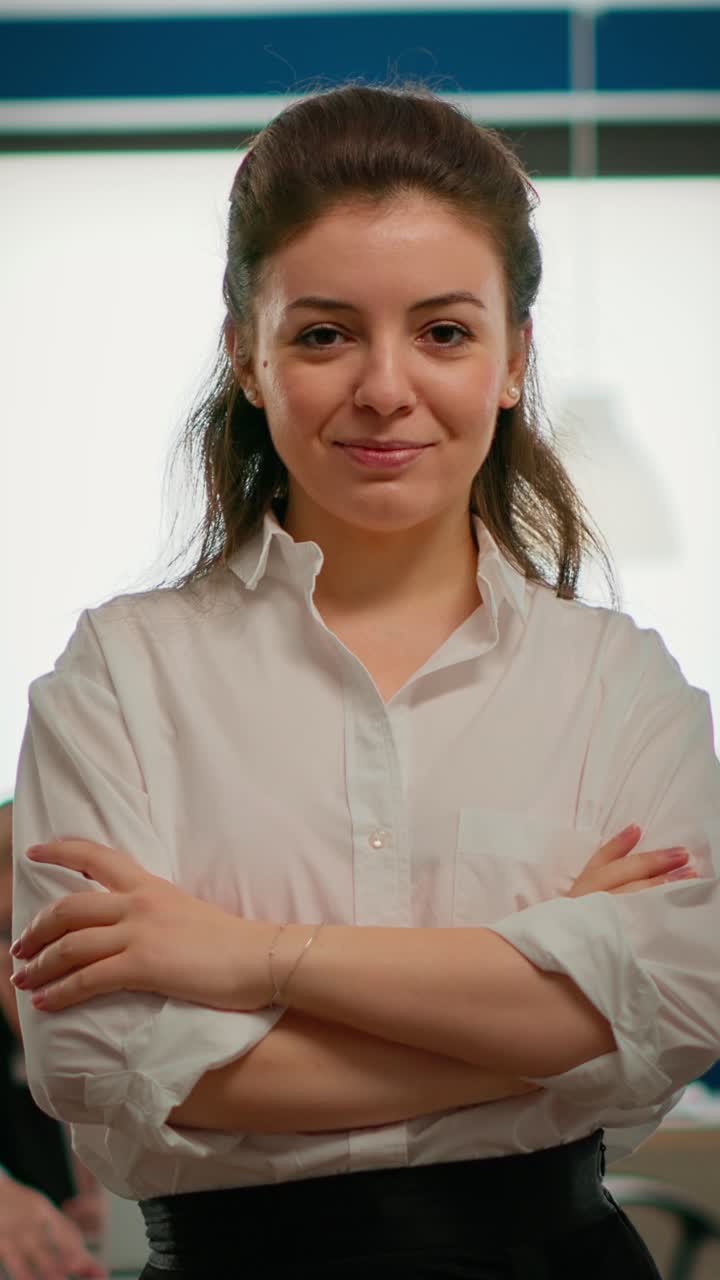 Vertical video Portrait of successful young entrepreneur looking at camera crossing arms