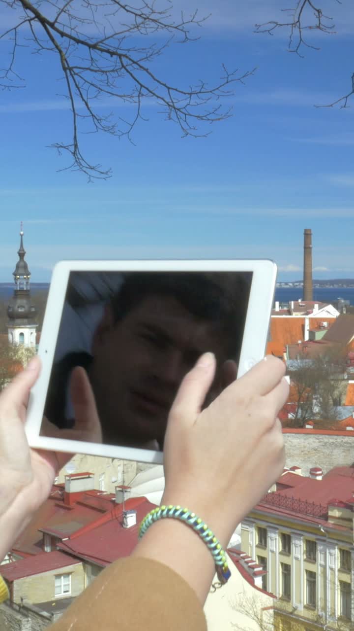 People taking pictures with a tablet in a cityscape setting