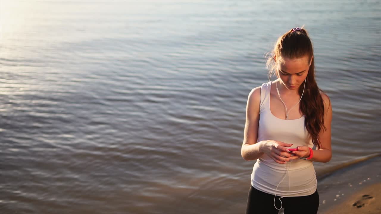 Young Woman Listening to Music While Exercising by the River